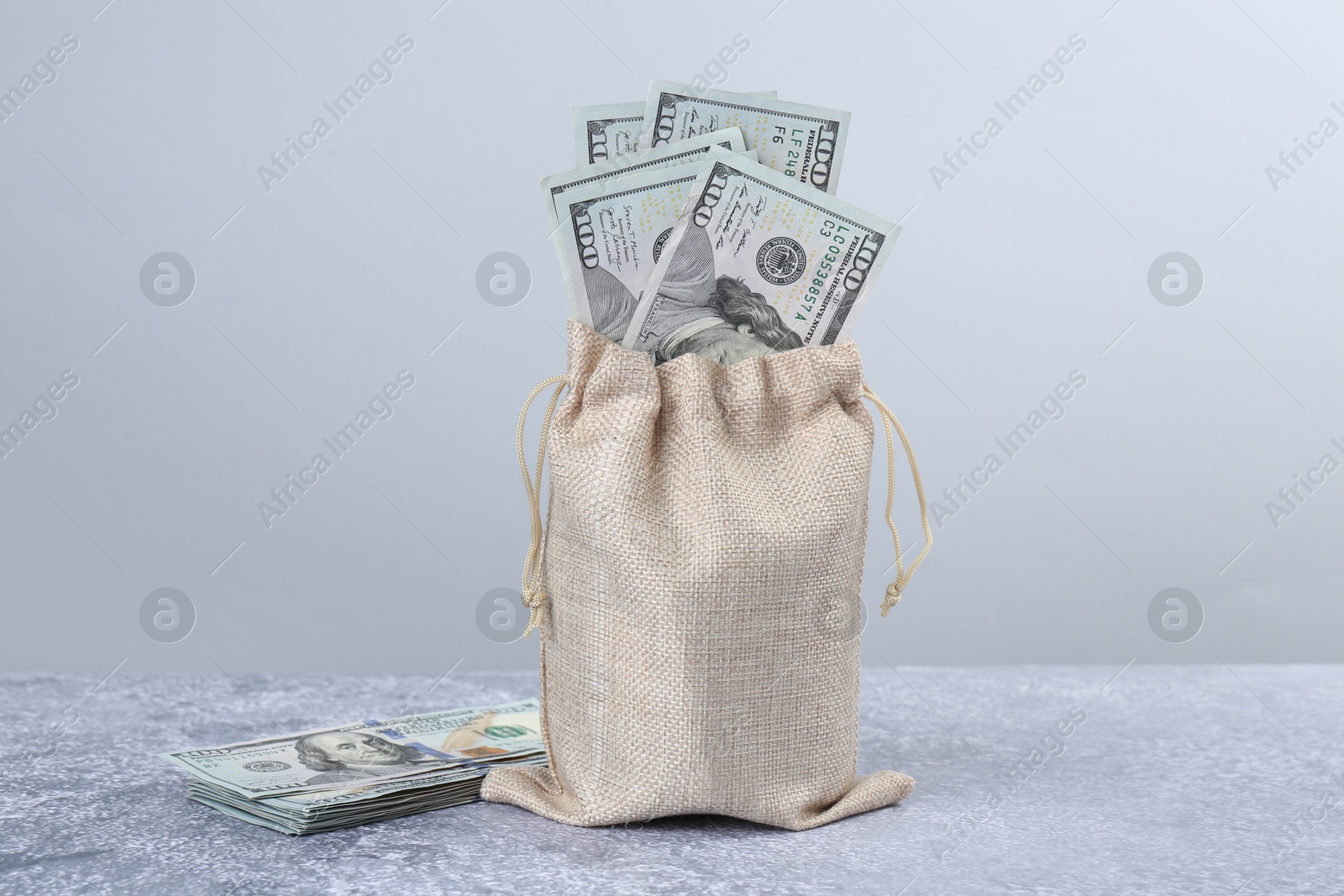 Photo of Dollar banknotes in bag on grey textured table