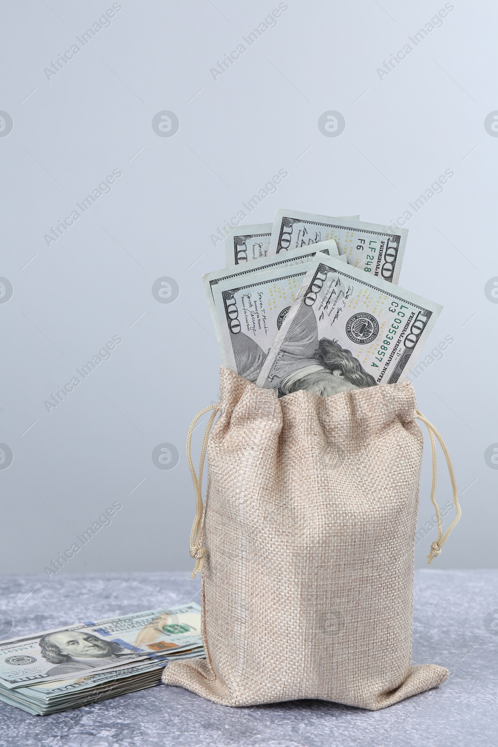 Photo of Dollar banknotes in bag on grey textured table