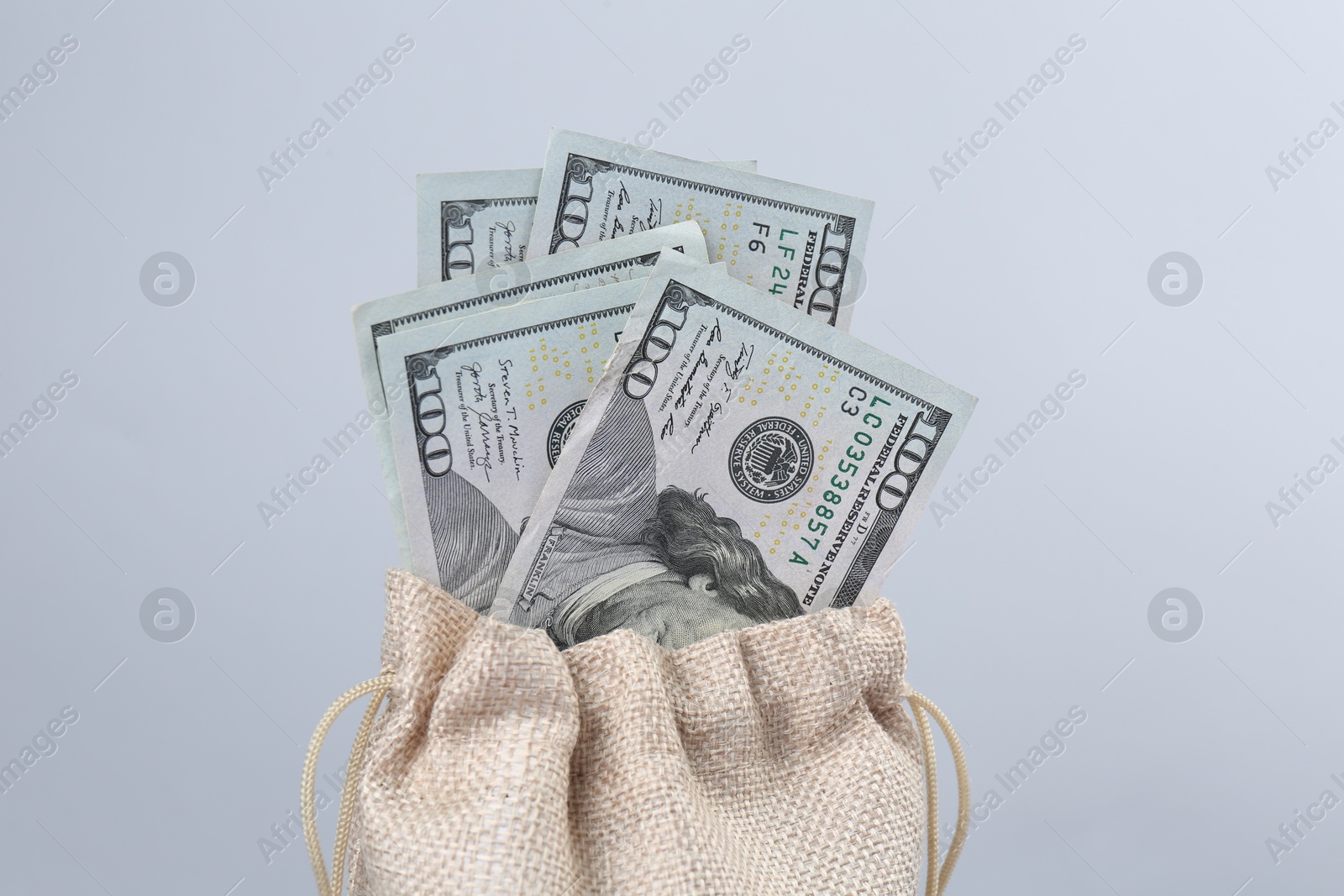 Photo of Dollar banknotes in bag against grey background, closeup