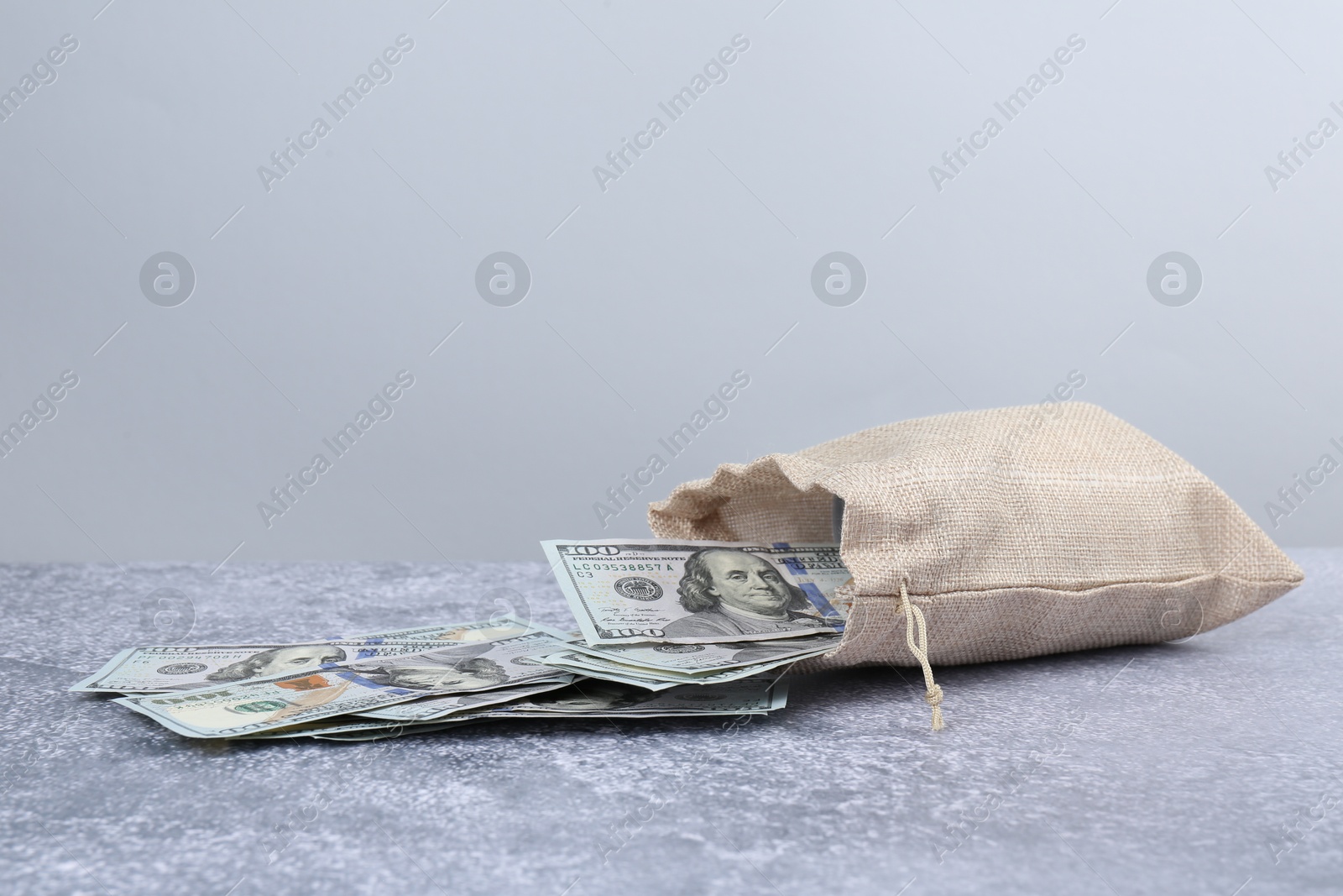 Photo of Dollar banknotes in bag on grey textured table