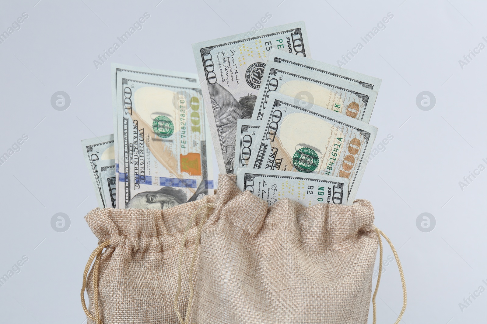 Photo of Dollar banknotes in bags on grey background, closeup