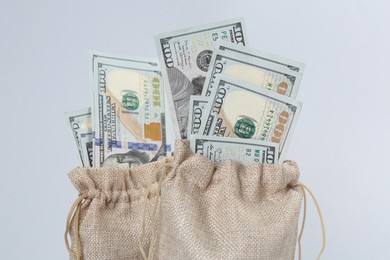 Photo of Dollar banknotes in bags on grey background, closeup