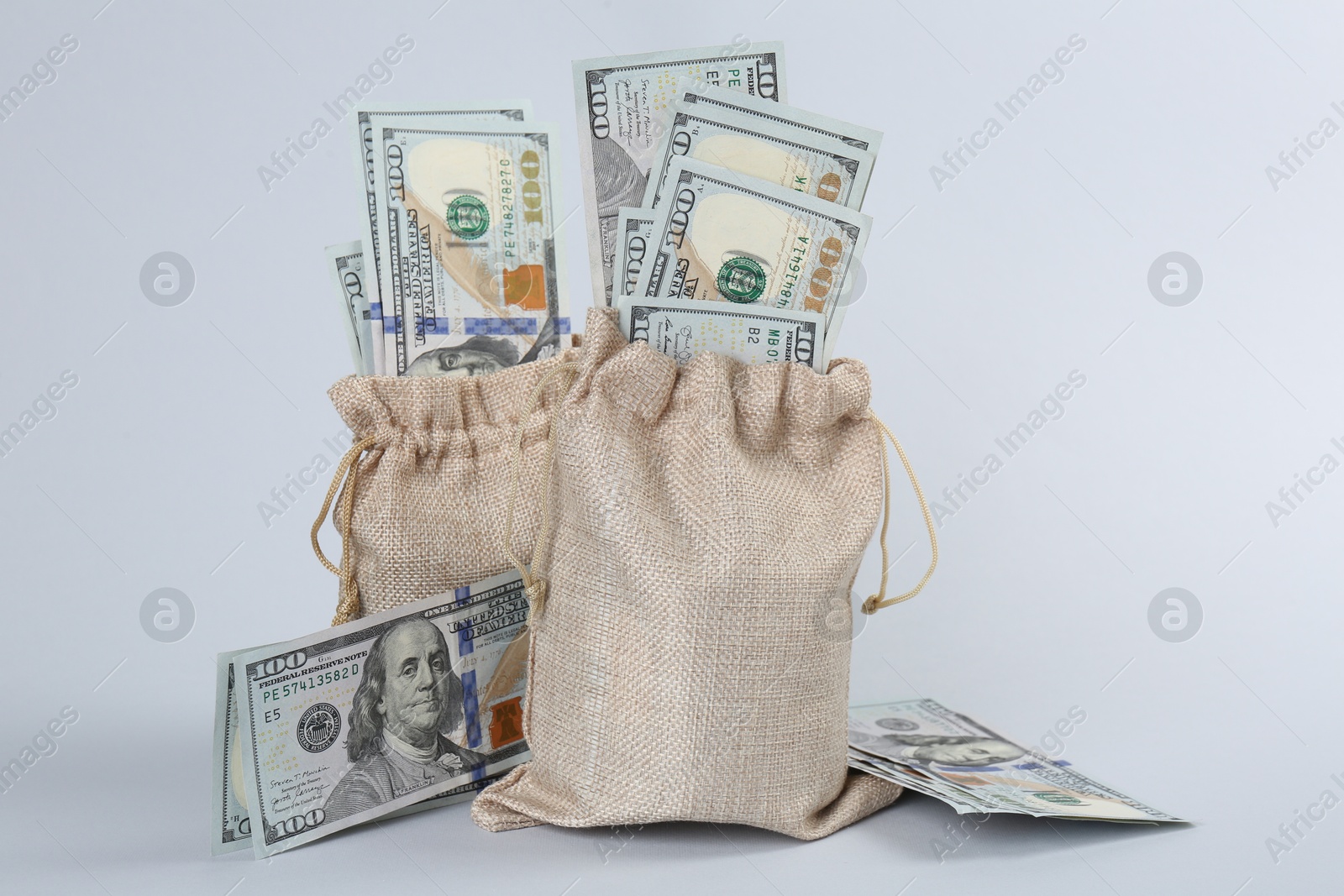 Photo of Dollar banknotes in bags on grey background