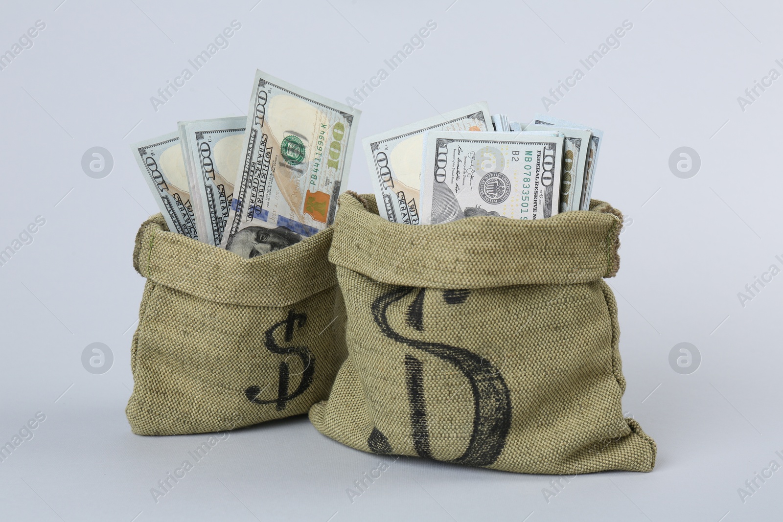 Photo of Dollar banknotes in bags on grey background