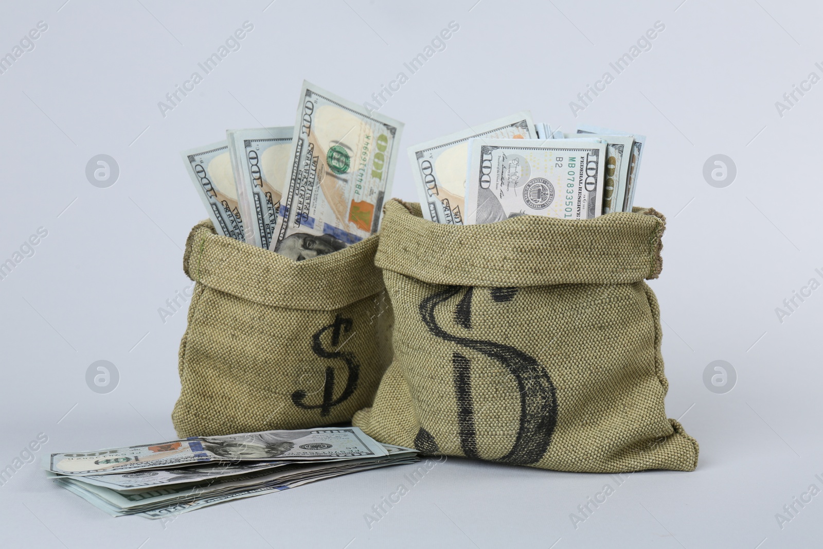 Photo of Dollar banknotes in bags on grey background