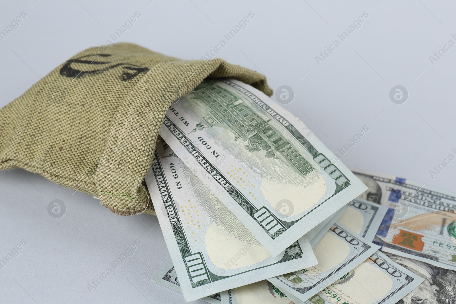 Photo of Dollar banknotes in bag on grey background, closeup