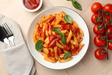 Photo of Delicious pasta with tomato sauce and basil in bowl served on wooden table, flat lay