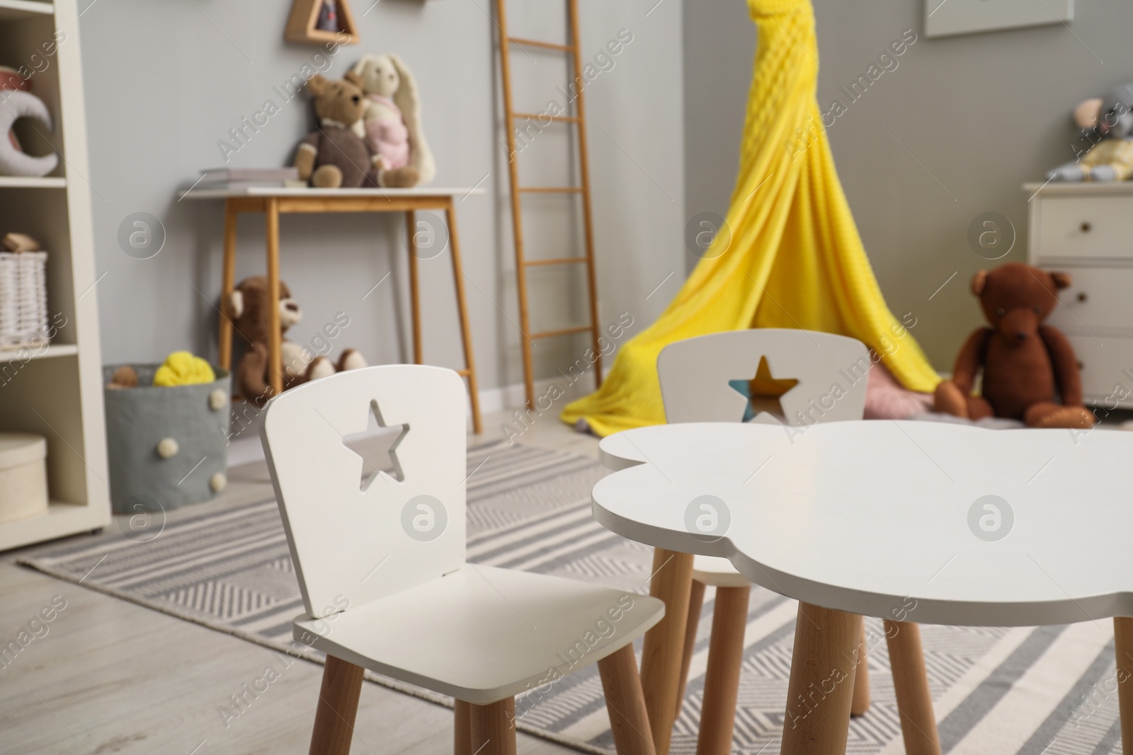 Photo of Stylish child room interior with modern furniture, toys and play tent