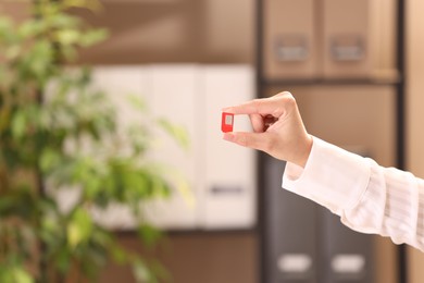 Photo of Woman holding SIM card indoors, closeup. Space for text