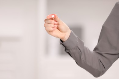 Photo of Woman holding SIM card indoors, closeup. Space for text