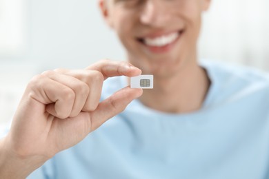 Man with SIM card at home, closeup