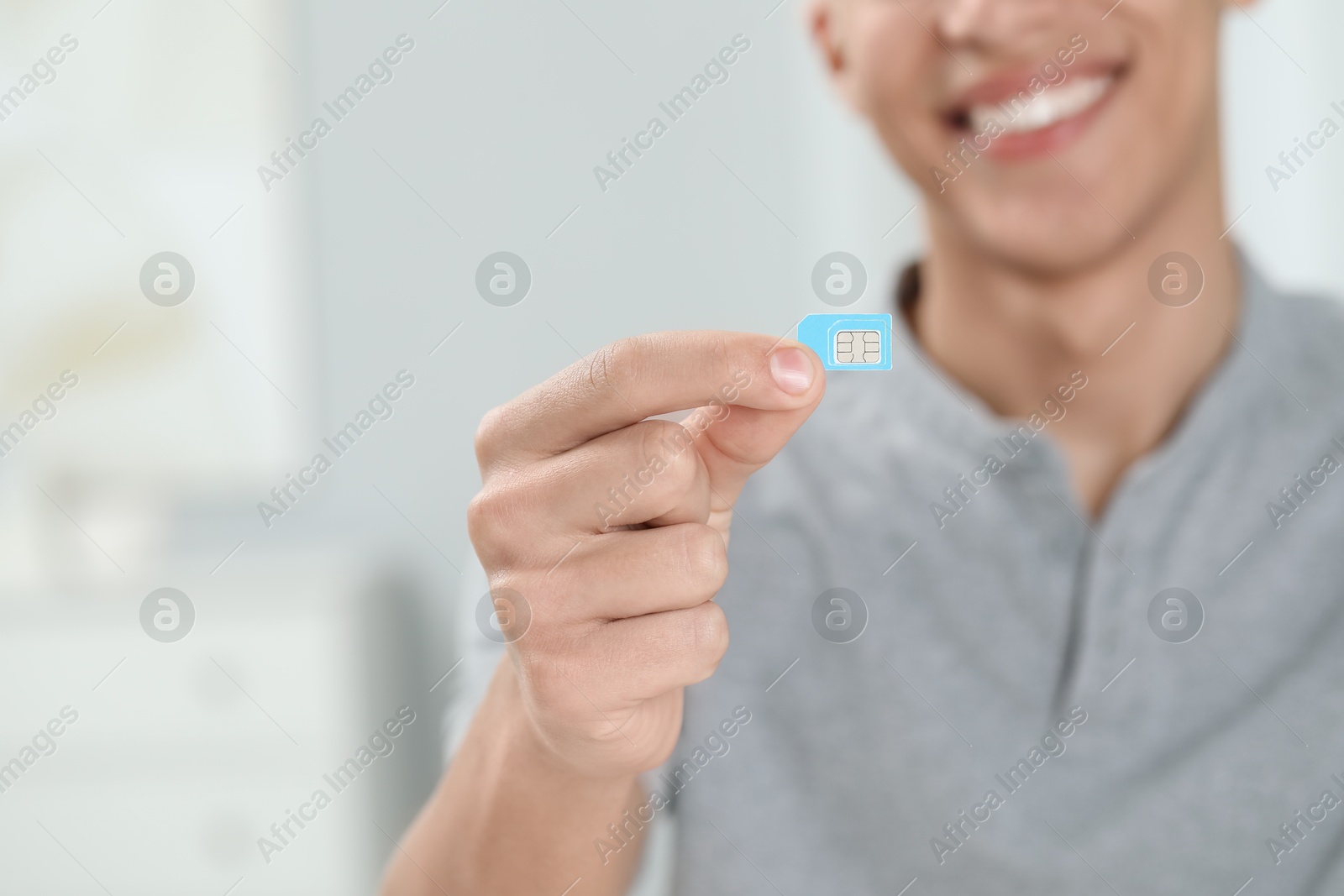 Photo of Man with SIM card indoors, closeup. Space for text