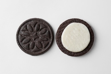 Photo of Halves of tasty sandwich cookie on white background, top view