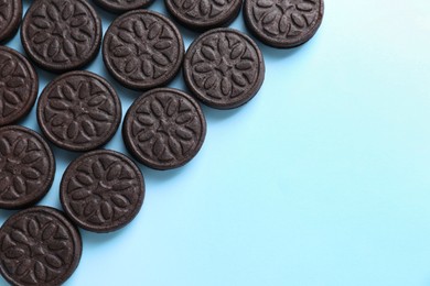 Photo of Tasty sandwich cookies on light blue background, top view. Space for text