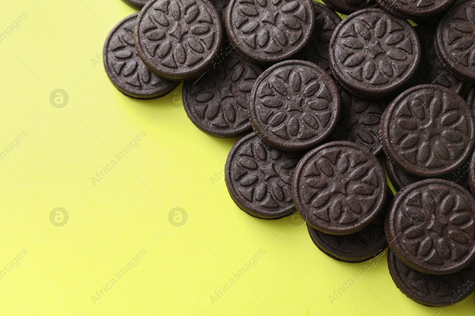 Photo of Tasty sandwich cookies on green background, top view. Space for text