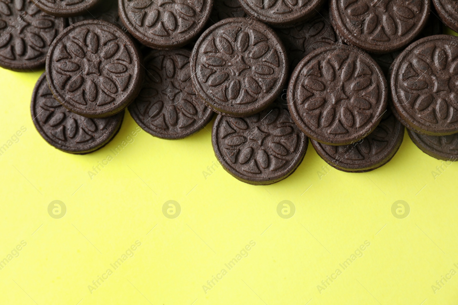 Photo of Tasty sandwich cookies on green background, top view. Space for text