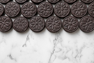 Tasty sandwich cookies on white marble table, top view. Space for text