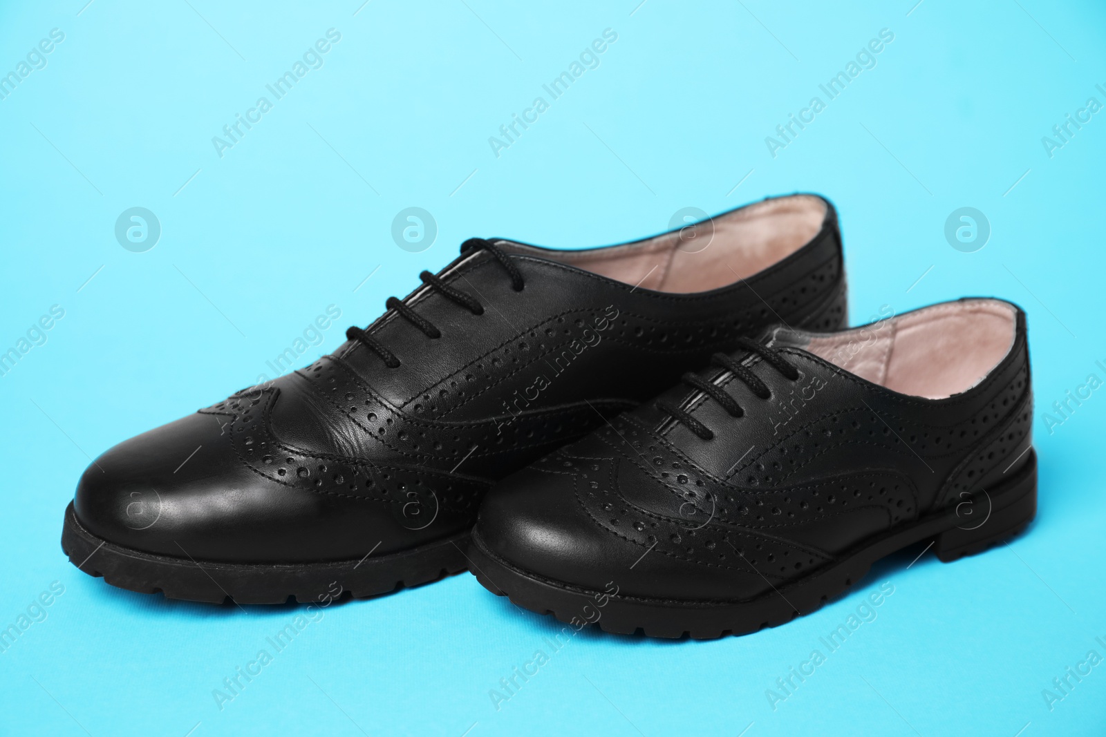 Photo of Big and small shoes on light blue background