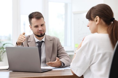 Consultant working with client at table in office. Business meeting