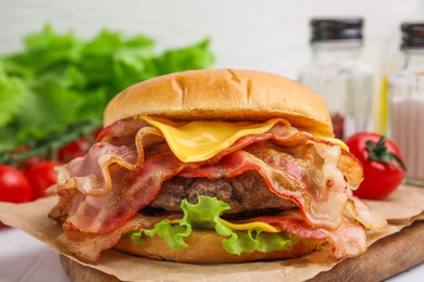 Photo of Delicious burger with bacon, patty and cheese on table, closeup