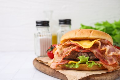 Photo of Delicious burger with bacon, patty and cheese on white table. Space for text