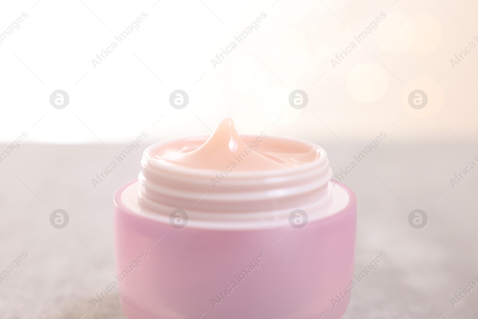 Photo of Jar of cream on gray table against light background, closeup, space for text