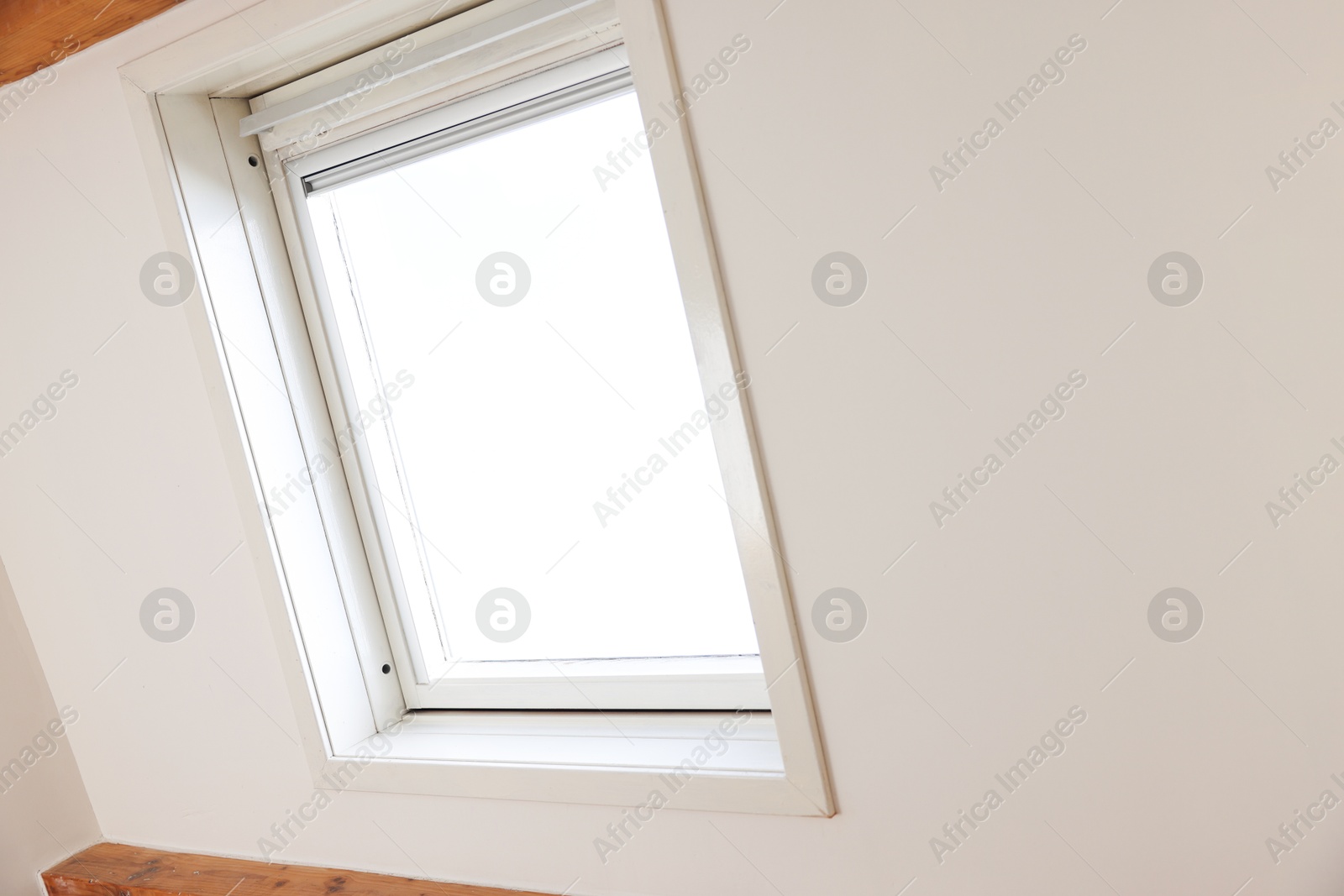 Photo of Roof window on slanted ceiling indoors, low angle view