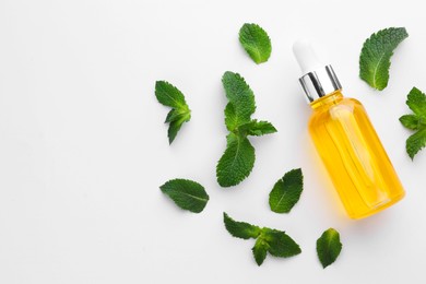 Photo of Bottle of essential oil and mint isolated on white, top view