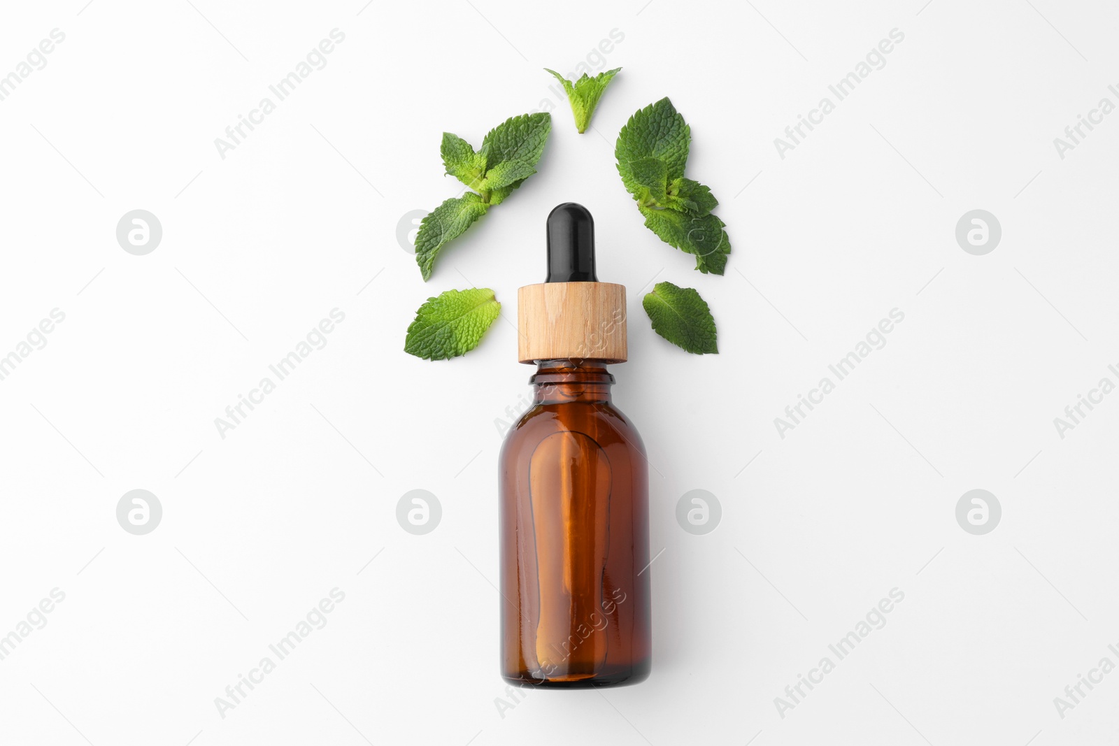 Photo of Bottle of essential oil and mint isolated on white, top view