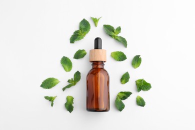 Photo of Bottle of essential oil and mint isolated on white, top view