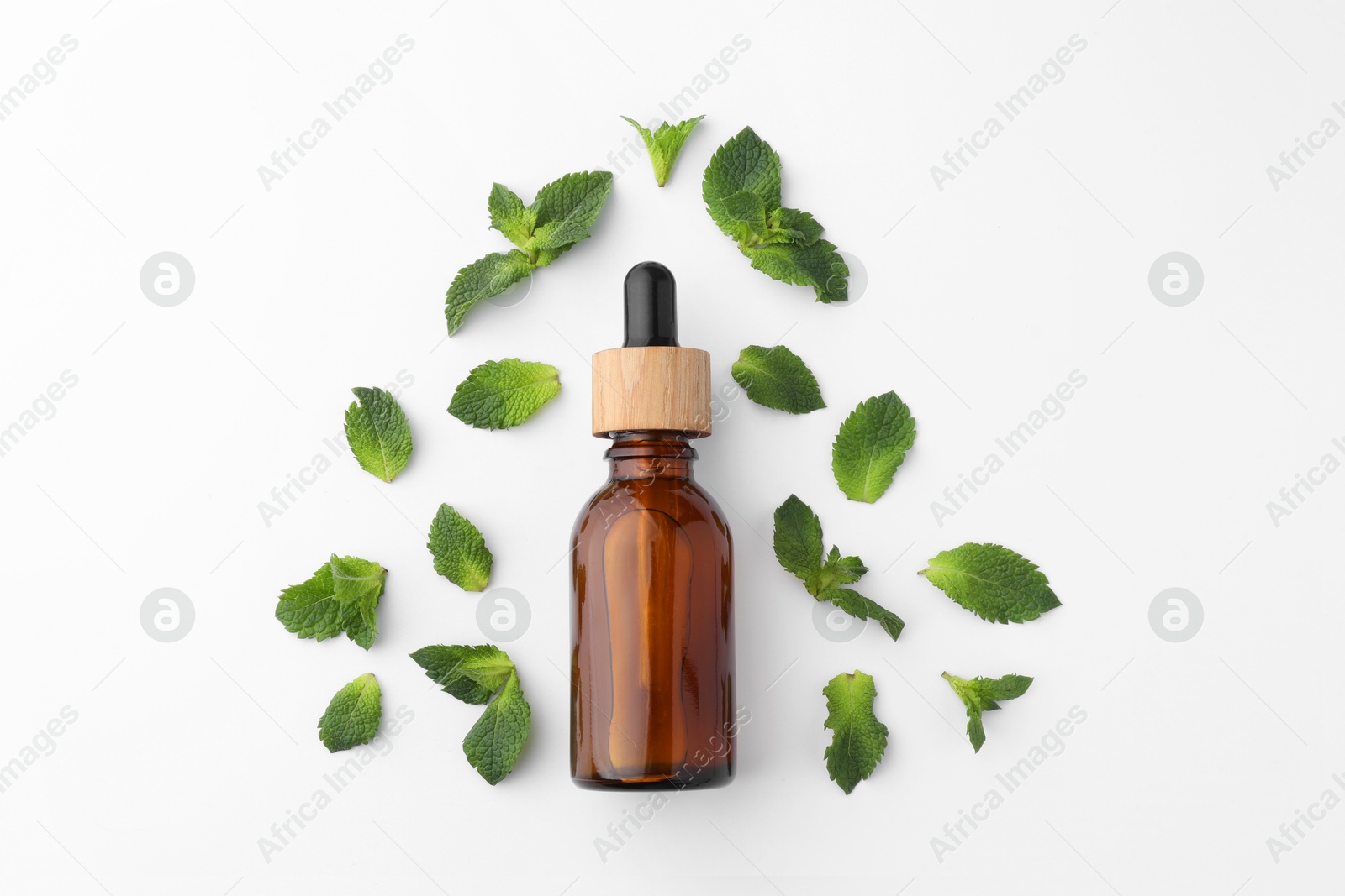 Photo of Bottle of essential oil and mint isolated on white, top view