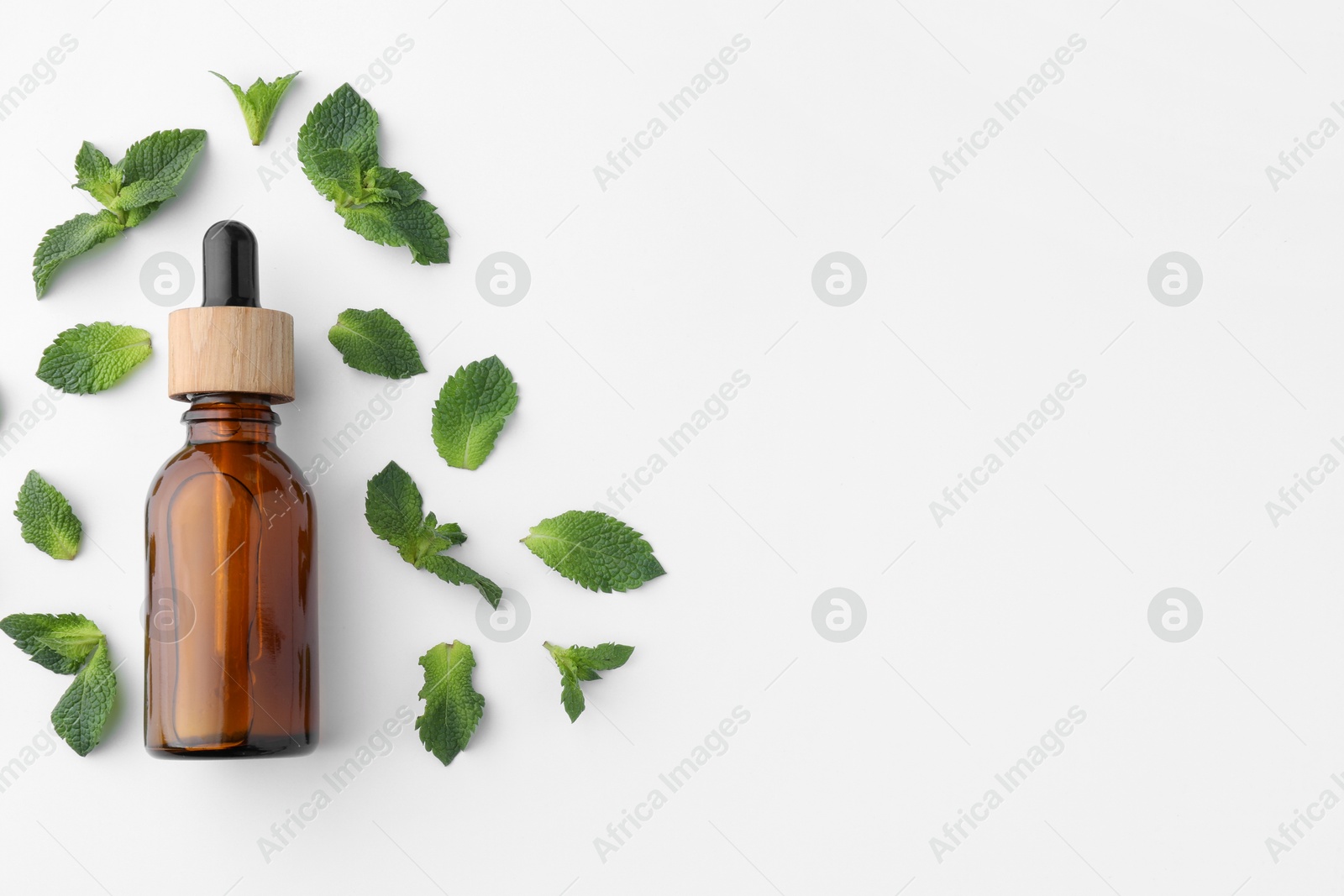 Photo of Bottle of essential oil and mint isolated on white, top view