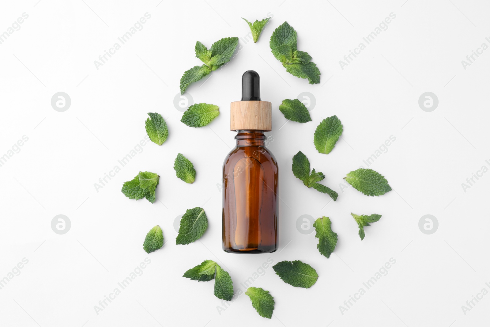 Photo of Bottle of essential oil and mint isolated on white, top view