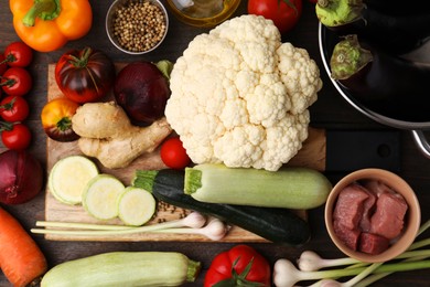 Different ingredients for stew on wooden table, top view