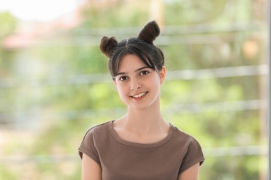 Photo of Portrait of smiling teenage girl on blurred background