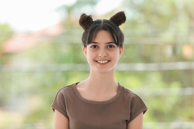 Photo of Portrait of smiling teenage girl on blurred background