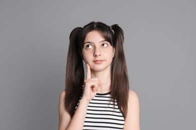 Portrait of cute teenage girl on grey background