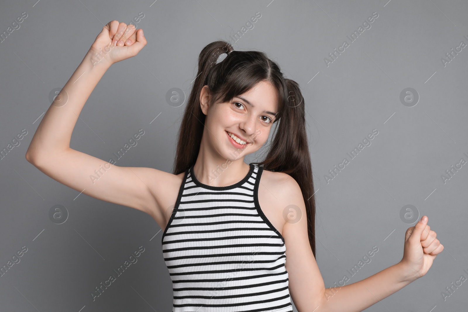 Photo of Portrait of smiling teenage girl on grey background