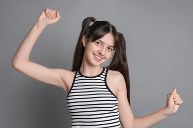 Photo of Portrait of smiling teenage girl on grey background