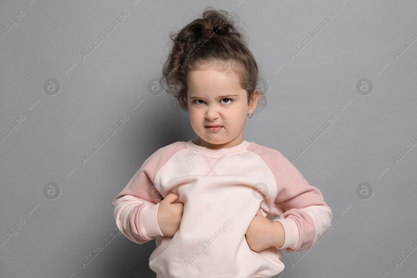 Photo of Adorable child. Portrait of cute girl on grey background