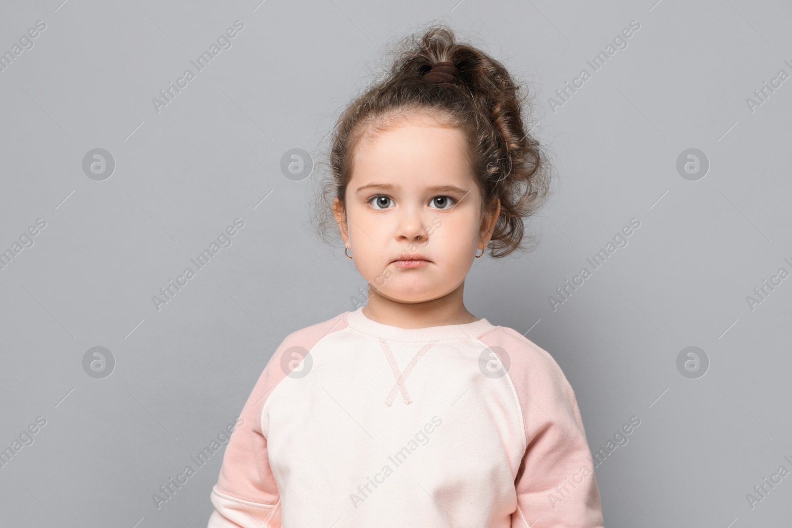 Photo of Adorable child. Portrait of cute girl on grey background