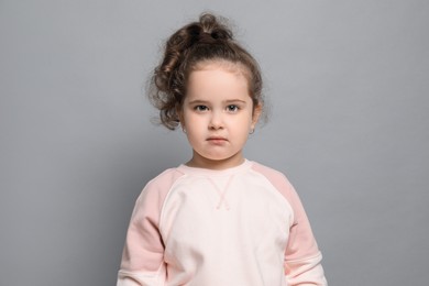 Photo of Adorable child. Portrait of cute girl on grey background