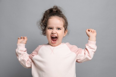 Photo of Adorable child. Portrait of emotional girl on grey background