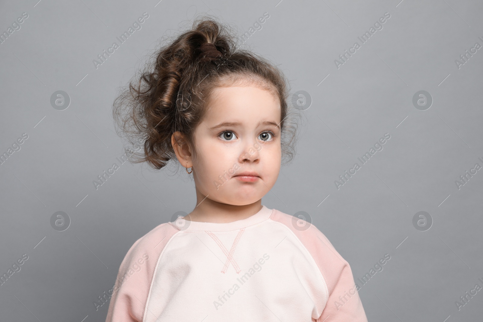 Photo of Adorable child. Portrait of cute girl on grey background