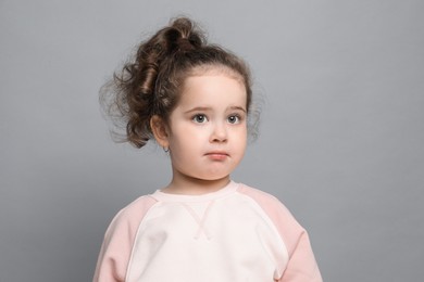 Photo of Adorable child. Portrait of cute girl on grey background