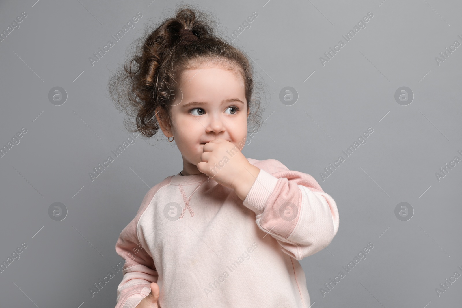 Photo of Adorable child. Portrait of cute girl on grey background