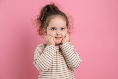 Photo of Adorable child. Portrait of cute girl on pink background