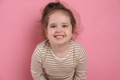 Adorable child. Portrait of happy girl on pink background