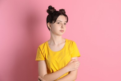 Portrait of cute teenage girl on pink background