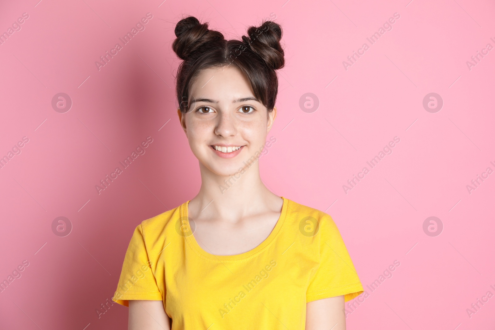 Photo of Portrait of smiling teenage girl on pink background